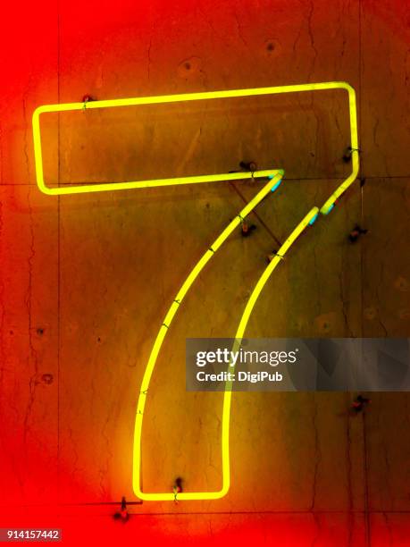 one digit number seven neon sign on concrete wall - an evening with 7 at 7 on the 7th stockfoto's en -beelden