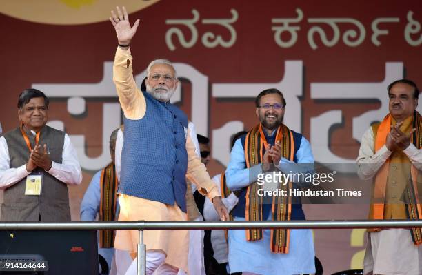 Prime Minister Narendra Modi waves hand as Karnataka state assembly leader of Opposition Jagdish Shettar, Union minister Prakash Javadekar, and...