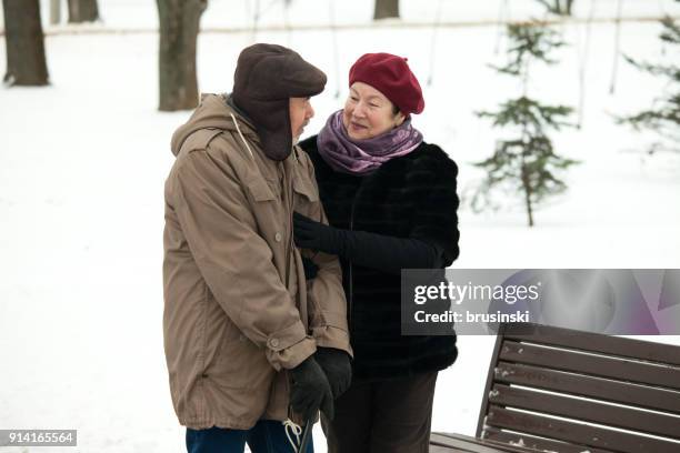 ältere mann und frau bei einem spaziergang im winter park - weißrussland stock-fotos und bilder