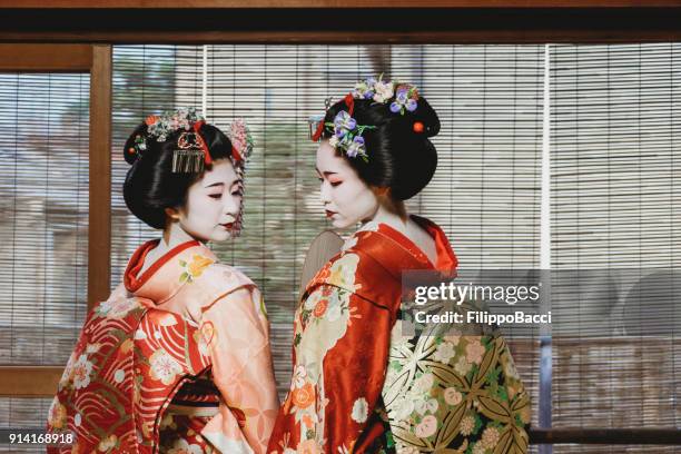 haltestelle maiko frauen zusammen in kyoto - geisha stock-fotos und bilder