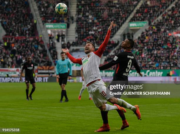 Frankfurt's French forward Sebastien Haller fouls Augsburg's German midfielder Daniel Baier during the German first division Bundesliga football...