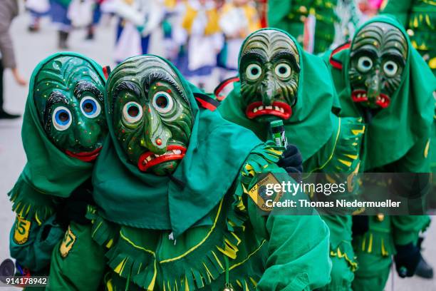 Revelers dressed in traditional colorful costumes and painted, wooden masks take part in the annual Fasnet carnival parade on February 4, 2018 in...