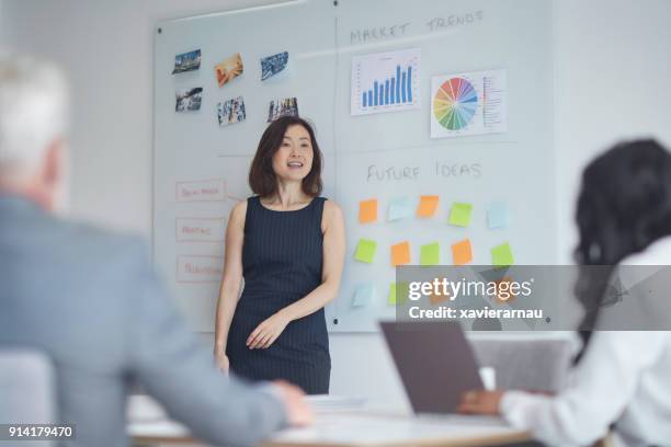 businesswoman giving presentation to colleagues - black man giving speech stock pictures, royalty-free photos & images