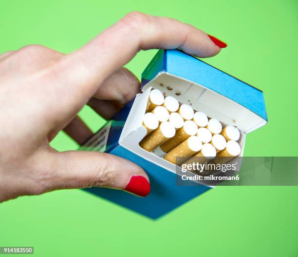 woman's hand taking cigarette from pack - zigarettenfilter stock-fotos und bilder