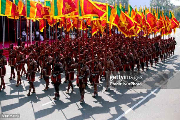 Sri Lankan Army soldiers carry Sri Lankan national flags dressed in traditional costumes during the 70th Independence Day parade at the Galle Face...