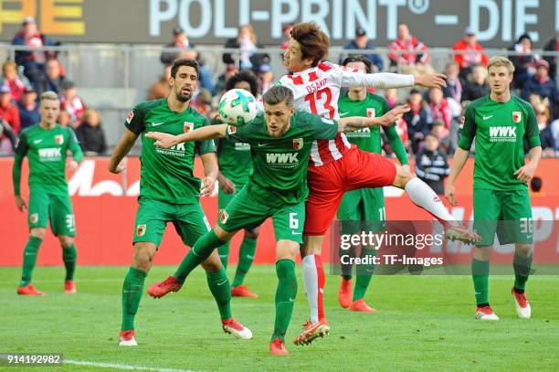 Jeffrey Gouweleeuw of Augsburg and Yuya Osako of Koeln battle for the ball during the Bundesliga match between 1 FC Koeln and FC Augsburg at...