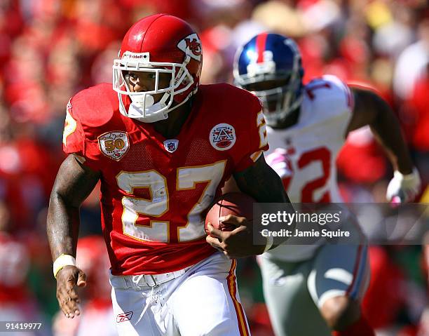 Running back Larry Johnson of the Kansas City Chiefs carries the ball as Osi Umenyiora of the New York Giants gives chase during the game on October...