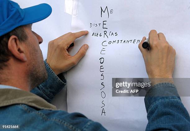 Man writes a message on a wall outside the Congress building as he waits to pay his respects to deceased Argentine singer Mercedes Sosa in Buenos...
