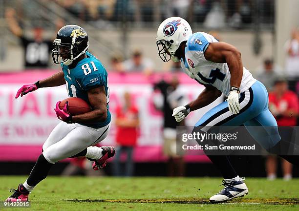 Torry Holt of the Jacksonville Jaguars is chased by Chris Hope of the Tennessee Titans during the game at Jacksonville Municipal Stadium on October...