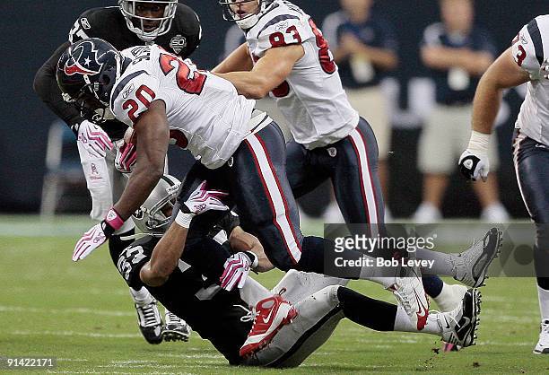 Running back Steve Slaton of the Houston Texans runs over safety Tyvon Branch of the Oakland Raiders at Reliant Stadium on October 4, 2009 in...