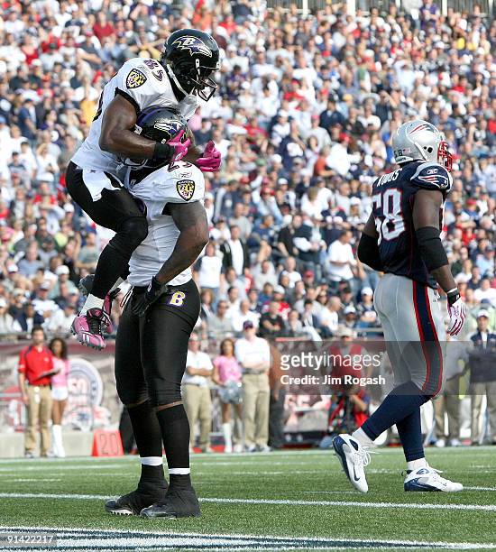 Willis McGahee of the Baltimore Ravens celebrates with teammate Derrick Mason after McGahee scored a touchdown against the New England Patriots at...