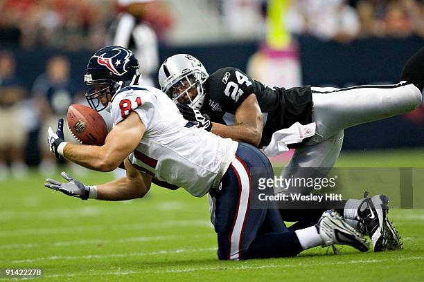 Owen Daniels of the Houston Texans catches a pass with Michael Huff of the Oakland Raiders on his back at Reliant Stadium on October 4, 2009 in...