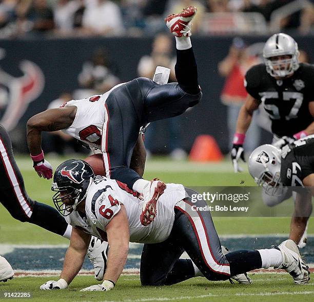 Runnig back Steve Slaton of the Houston Texans trips over guard Kasey Studdard at Reliant Stadium on October 4, 2009 in Houston, Texas.