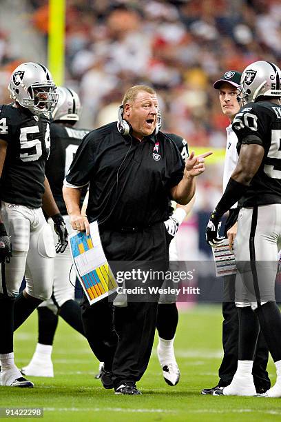 Head Coach Tom Cable of the Oakland Raiders talks with his players during a game against the Houston Texans at Reliant Stadium on October 4, 2009 in...