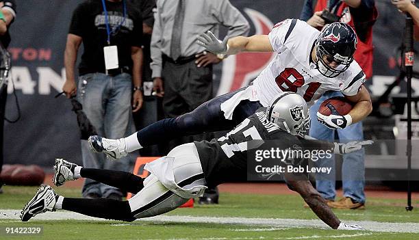 Tight-end Owen Daniels of the Houston Texans is knocked out of bounds by cornerback Chris Johnson of the Oakland Raiders at Reliant Stadium on...