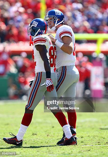 Quarterback Eli Manning of the New York Giants consoles receiver Mario Manningham after an interception during the game against the Kansas City...