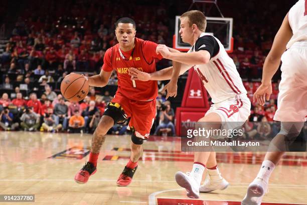 Anthony Cowan Jr. #1 of the Maryland Terrapins dribbles around Brad Davison of the Wisconsin Badgers during a college basketball game at Xfinity...