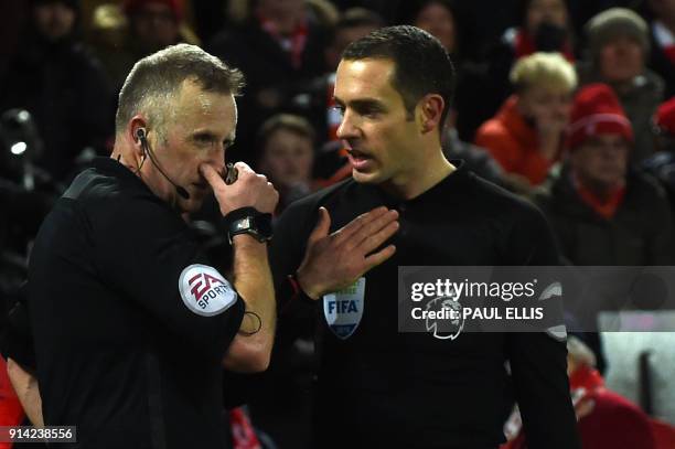 Referee Johnathan Moss discusses the first penalty with the linesman during the English Premier League football match between Liverpool and Tottenham...