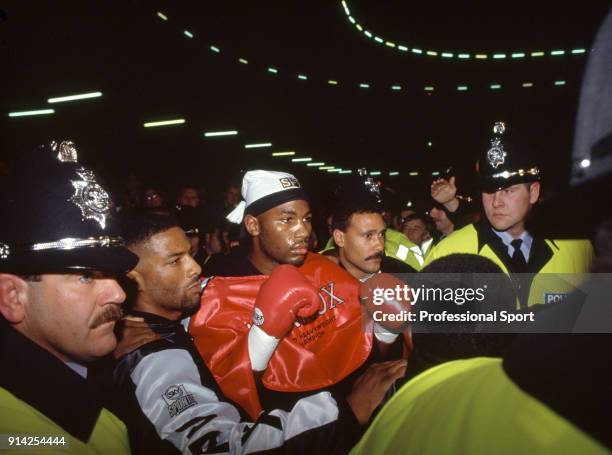 Lennox Lewis of Great Britain is led out of the arena amongst security after knocking out Frank Bruno of Great Britain in the seventh round of their...