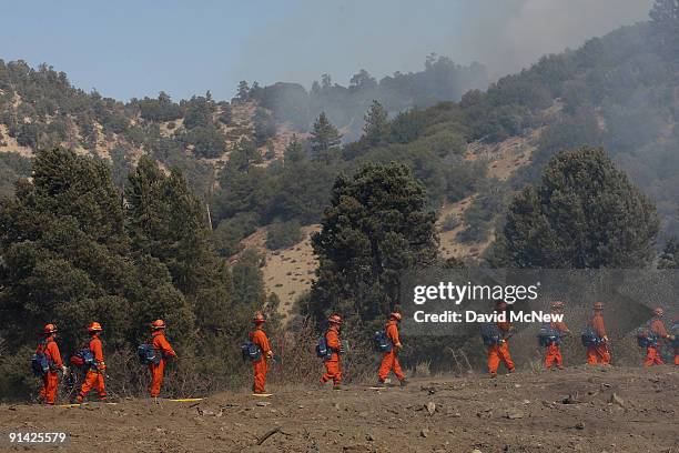 An inmate hand crew marches to their next assignment try to prevent the 3,500-acre Sheep fire from reaching the mountain town of Wrightwood, a...