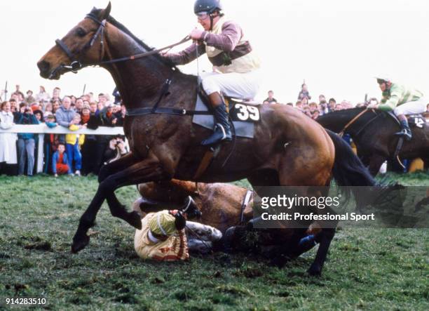 Jockey Carl Llewellyn and his horse Kumbi fall at Becher's Brook as number 39 Seeandem, ridden by Pat Leech, takes evasive action during the Grand...