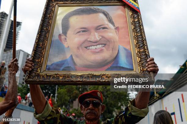 Soldier holds a portrait of late Venezuelan President Hugo Chavez during a rally to commemorate the 26th anniversary of former Chavez's 1992 military...