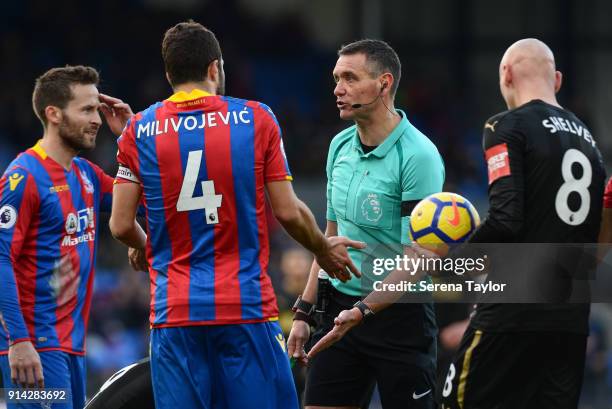 Referee Andre Marriner talks to Yohan Cabaye and Luka Milivojevic of Crystal Palace during the Premier League match between Crystal Palace and...