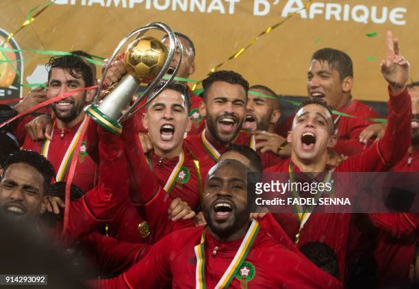 Morocco's players hold up the trophy as they celebrate after winning the final football match of the African Nations Championship against Nigeria at...