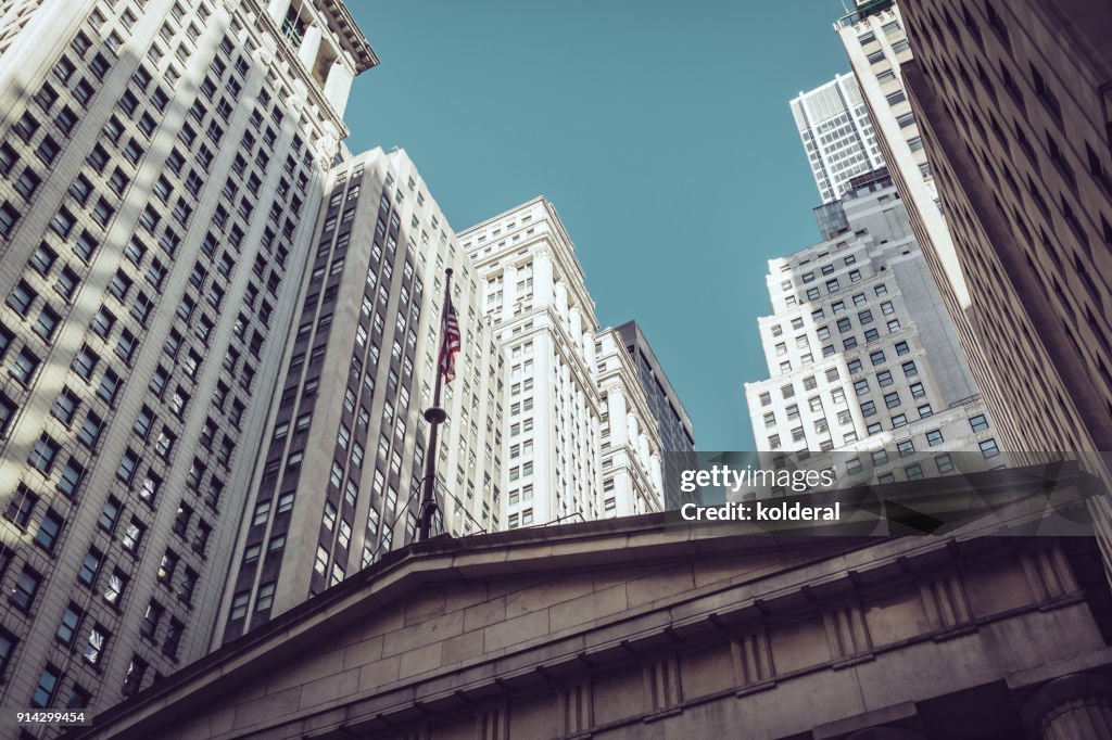 Office buildings next to Federal Hall National Memorial with statue of George Washington on Wall street