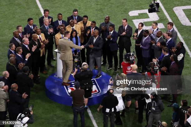 Watt of the Houston Texans is presented with the Walter Payton NFL Man of the Year trophy prior to the game between the New England Patriots and the...