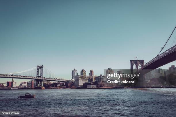 brooklyn bridge and manhattan bridge at midday against blue sky - midday stock pictures, royalty-free photos & images
