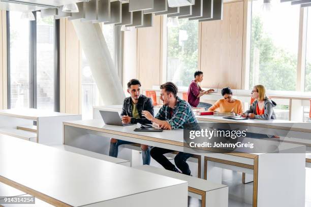 grupo de estudiantes universitarios trabajando en escritorio en el aula moderna - snapshot of britain fotografías e imágenes de stock