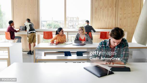 multi racial group of college students working in modern building interior - modern classroom stock pictures, royalty-free photos & images