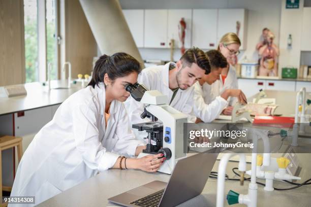 wetenschapsstudenten in laboratorium met behulp van microscopen, laptop op werkbank - indian education health science and technology stockfoto's en -beelden