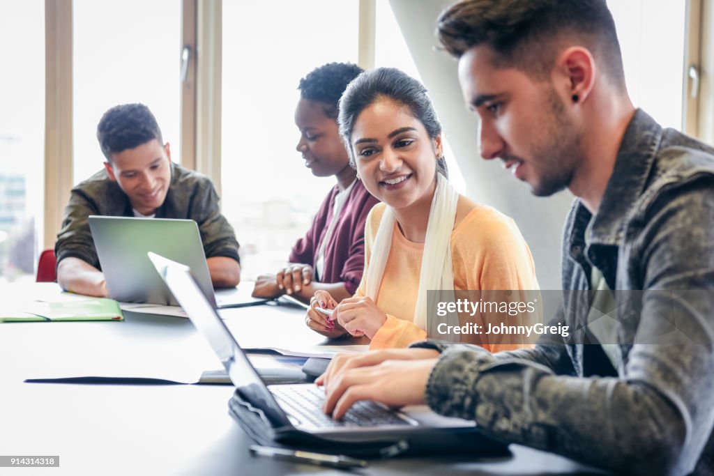 Hombre joven con laptop estudiante mirando y sonriendo