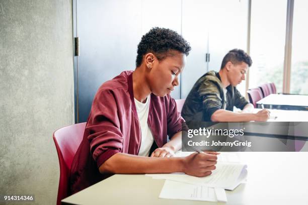 female student taking exam at college - paper england imagens e fotografias de stock