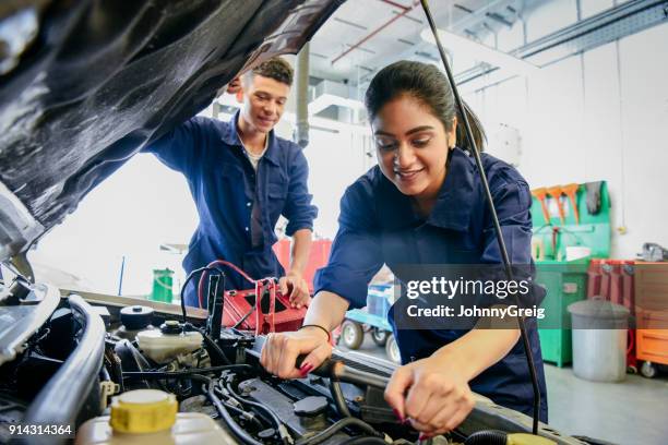 weibliche mechaniker festsetzung auto, junger mann beobachten - asian engineer stock-fotos und bilder