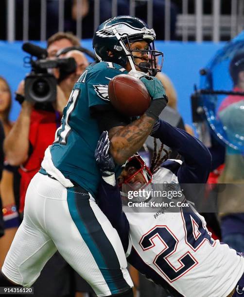 Alshon Jeffery of the Philadelphia Eagles bobbles the pass under pressure from Stephon Gilmore of the New England Patriots as teamamte Duron Harmon...