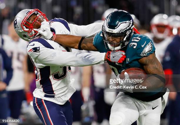 Corey Clement of the Philadelphia Eagles runs the ball past Duron Harmon of the New England Patriots for a 55-yard gain during the second quarter in...