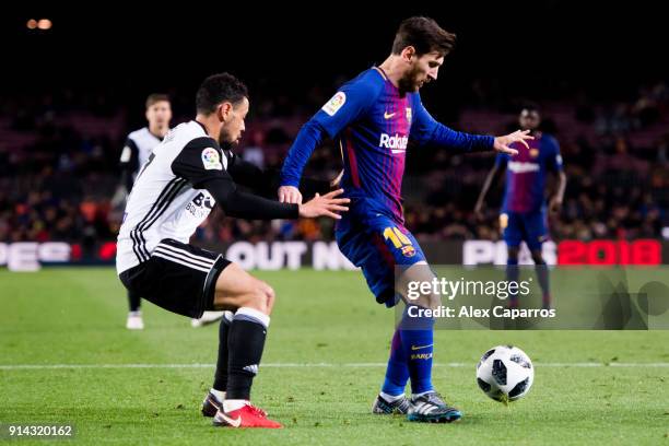 Lionel Messi of FC Barcelona dribbles Francis Coquelin of Valencia CF to assist his teammate Luis Suarez to score the opening goal during the Copa...