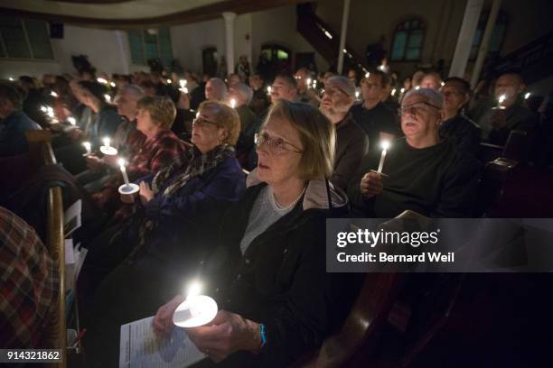 Lights are dimmed as members of the congregation sing the closing song "Channel Your Peace" at The Metropolitan Community Church, which held a...