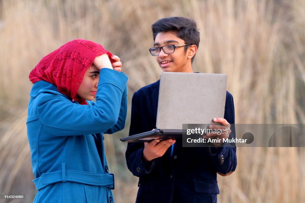 Boy And A Girl Working Outdoor On Digital Laptop