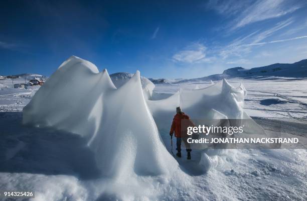 An organiser builds a structure of ice ahead of the Ice Music Festival on February 2, 2018 in the small mountain village of Finse in the municipality...