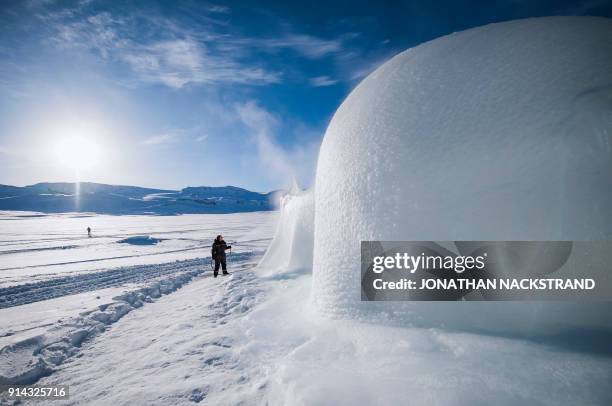 An organiser sprays water towards a structure of ice ahead of the Ice Music Festival on February 2, 2018 in the small mountain village of Finse in...