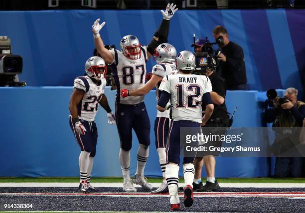 Rob Gronkowski of the New England Patriots celebrates his four yard touchdown catch with teammates James White Chris Hogan and Tom Brady during the...