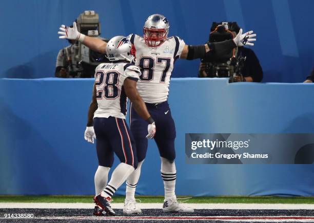 Rob Gronkowski of the New England Patriots celebrates his four yard touchdown catch with teammates James White during the third quarter against the...