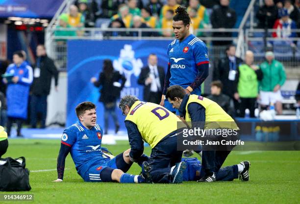 Matthieu Jalibert of France lies injured while Teddy Thomas looks on during the NatWest 6 Nations match between France and Ireland at Stade de France...