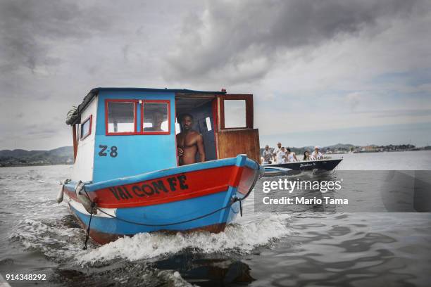 Candomble followers ride boats towards the center of Guanabara Bay on their way to place flowers into the bay as offerings honoring Iemanja, Goddess...