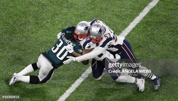 Corey Clement of the Eagles collides with Patrick Chung and Kyle Van Noy of the Patriots during Super Bowl LII between the New England Patriots and...
