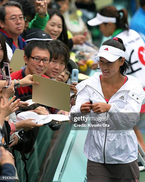 Kimiko Date Krumm of Japan signs autographs for fans after playing her doubles match with her partner Rika Fujiwara of Japan against Yurina Koshino...